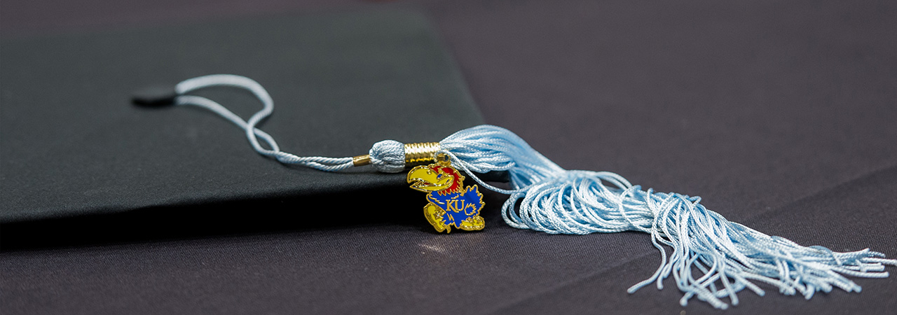 Image of a graduation cap with a Jayhawk tassle.